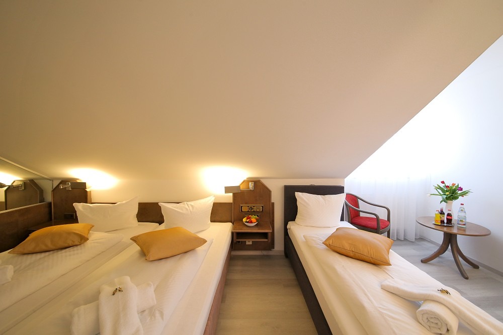 Gemütliches Dachzimmer mit goldenen Kissen.
